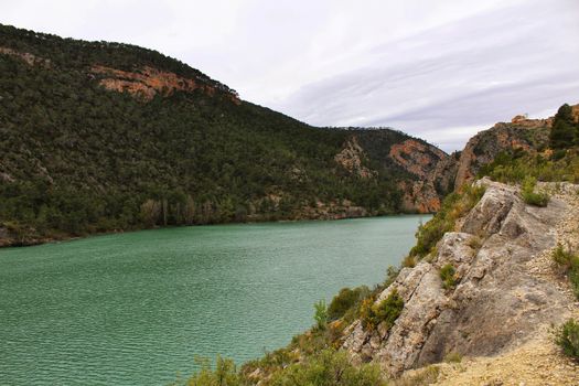 Swamp surrounded by mountains and colorful vegetation in El Molinar, Casas de Ves, Spain. Crystal Clear Waters of Cabriel River