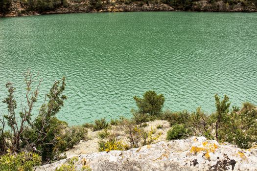 Swamp surrounded by mountains and colorful vegetation in El Molinar, Casas de Ves, Spain. Crystal Clear Waters of Cabriel River