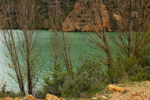 Swamp surrounded by mountains and colorful vegetation in El Molinar, Casas de Ves, Spain. Crystal Clear Waters of Cabriel River