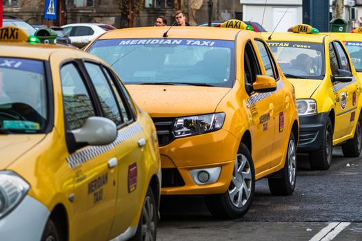 Car in traffic, modern city taxi service. Taxi cars parked at the taxi station in the capital city of Bucharest, Romania, 2020