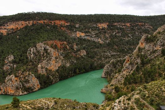 Swamp surrounded by mountains and colorful vegetation in El Molinar, Casas de Ves, Spain. Crystal Clear Waters of Cabriel River