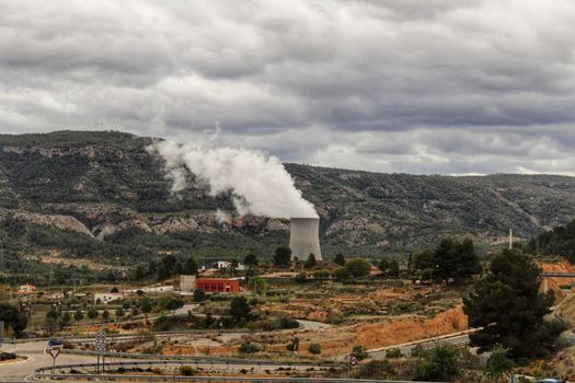 Smoking chimneys in Cofrentes nuclear power plant between mountains in Valencia, Spain