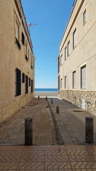 Lonely Little street between buildings facing the sea in Santa Pola, Spain
