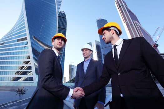 Investor and contractor shaking hands, view from below