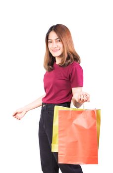 young woman pretty smiling holding paper bags green and orange shopping. on white background and looking at camera