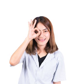 woman showing OK hand sign over eye on white background