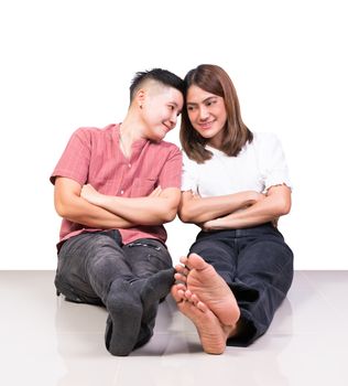 Two smiling woman young girls and happiness tomboy friends sitting on tile floor with white background
