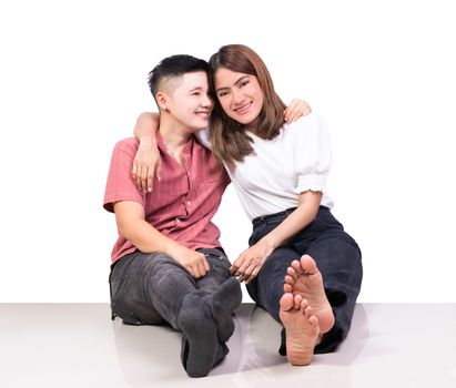 Two smiling woman young girls and happiness tomboy friends sitting on tile floor with white background