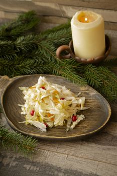 Fermented vegetables cabbage, cauliflower, carrot with cabbage and cronberry on wooden background. Winter concept