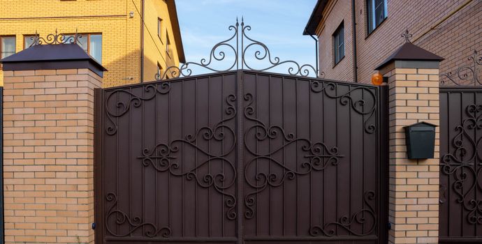 New forged metal double gates for entry of cars into the yard closed.