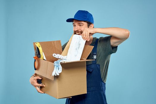 Worker man in uniform box tools construction blue background. High quality photo