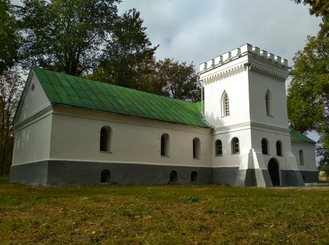 Kamenitsa Lizogubov, Ukraine. An old brick building with a tower, stone walls with windows, a castle on a green hill.