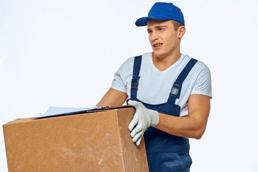 Man worker with box in hands delivery loading service work light background. High quality photo