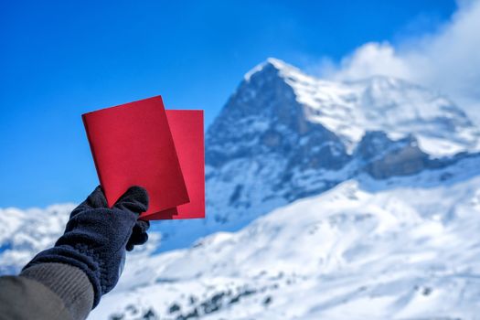 Tourists see beautiful viewpoitn near Kleine Scheidegg station and showing red card and snow mountain background 