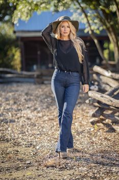 A gorgeous blonde model poses outdoors in her fall clothes