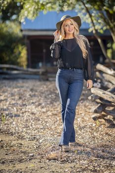 A gorgeous blonde model poses outdoors in her fall clothes