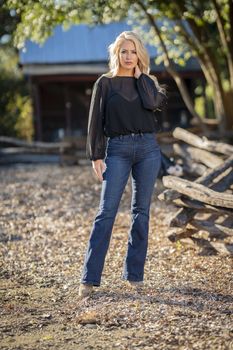 A gorgeous blonde model poses outdoors in her fall clothes