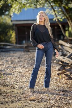 A gorgeous blonde model poses outdoors in her fall clothes