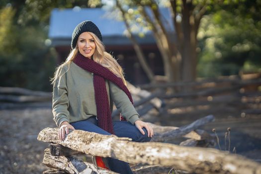 A gorgeous blonde model poses outdoors in her fall clothes