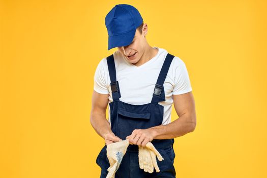 Man in working uniform documents rendering of services delivery service yellow background. High quality photo