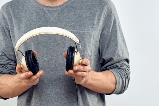 Man holding headphones in the hands of a man lifestyle modern style technology cropped view. High quality photo