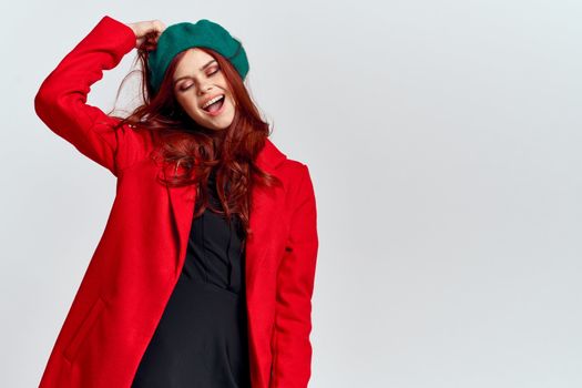 Woman in red coat and in green hat on isolated background cropped model with Copy Space emotions. High quality photo