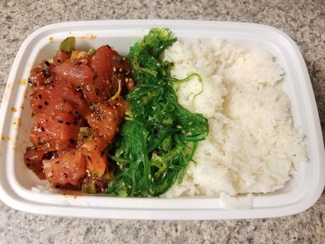 raw tuna fish Hawaiian poke with seaweed and rice in container on counter