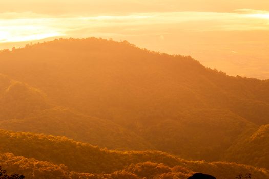 Beautiful landscape at sunset sky with clouds on peak of mountains.