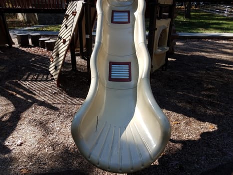 metal rollers on plastic playground play structure slide at park