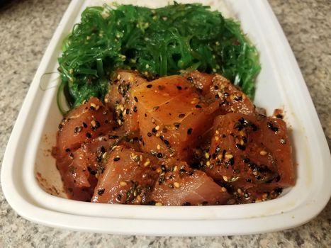 raw tuna fish Hawaiian poke with seaweed and rice in container on counter