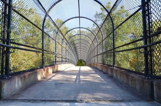 path or trail with metal fence over highway or road