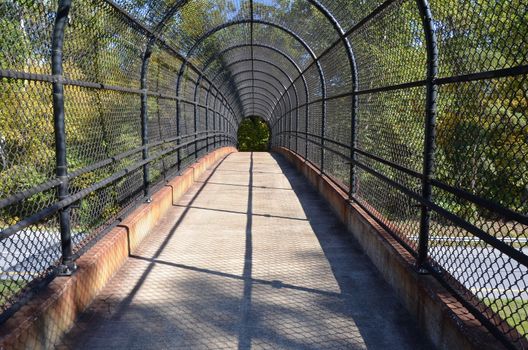 path or trail with metal fence over highway or road