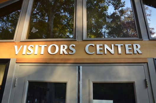 visitors center sign on building with doors and windows
