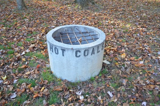 cement hot coal container or bin with metal bars and leaves