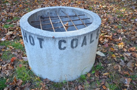 cement hot coal container or bin with metal bars and leaves