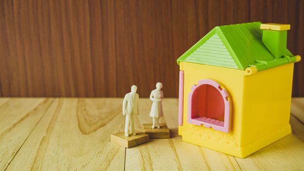 The home toy  and white human figure on wood table for property, building content.