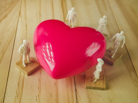 The pink heart and white figure on wood table for Health, medical content.