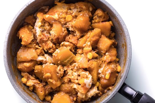 homemade stir fried pumpkin with egg and corn in pan on white background, healthy gourmet food recipe, good work from home lunch idea, table top view