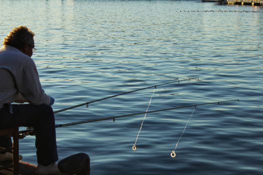 Santa Pola, Spain-December 4, 2017: Man fishing in the port of Santa Pola in the afternoon