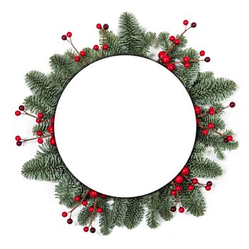 Christmas Border frame of tree branches and red berries on white background with copy space isolated