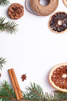 Christmas composition with dried citrus slices, cinnamon, anise, pine cones and fir tree branches, top view copy space