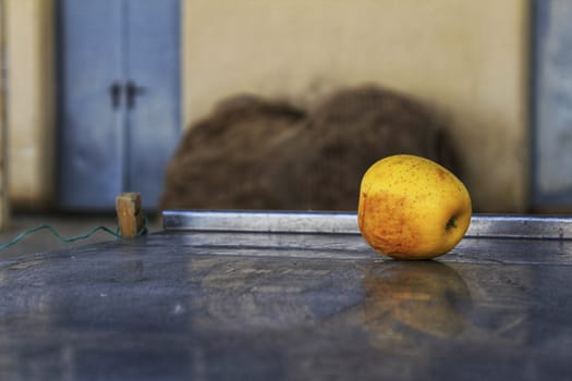 Abandoned yellow apple over metal surface on the street in Spain