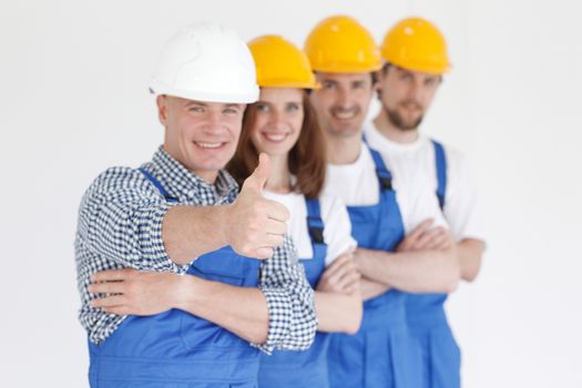 Team of happy workers in uniform ready to work, man showing thumb up sign