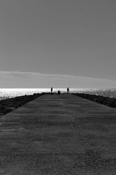 Fishing day on a breakwater under the sun in Santa Pola, Spain