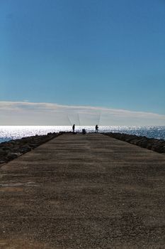 Fishing day on a breakwater under the sun in Santa Pola, Spain