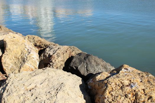 Reflections in the sea and rocks under the sun in Santa Pola, Spain