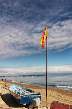 Fishing boats on the shore under spanish flag in the morning