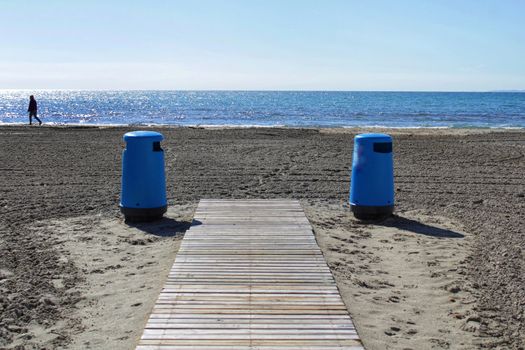Wastebaskets and walkway to the beach in the morning