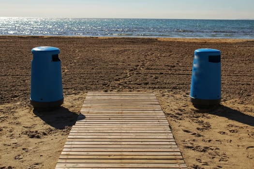 Wastebaskets and walkway to the beach in the morning