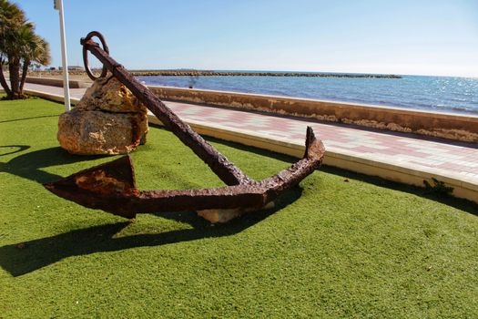 Santa Pola, Spain- February 16, 2018: Old anchor on a promenade of Santa Pola, Alicante. Mediterranean sea on background.